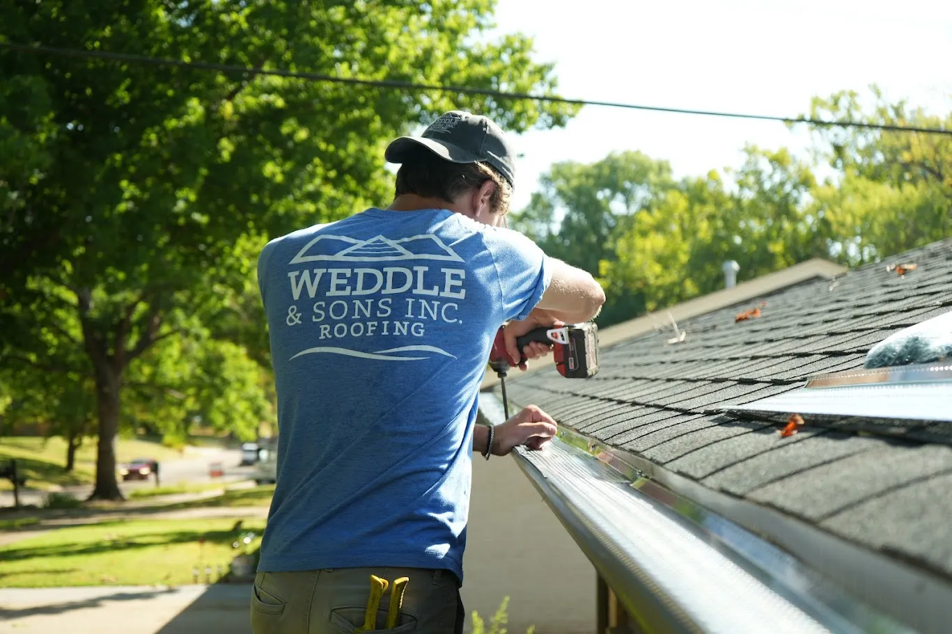 Weddle and Sons installer fastening perforated aluminum gutter protection