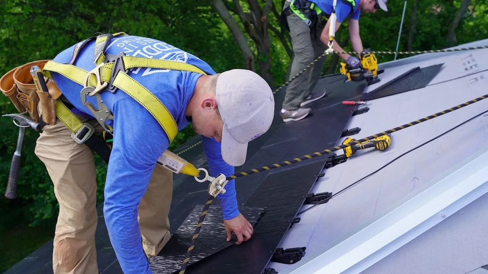 Weddle and Sons roofers in safety harnesses installing solar roof tiles near Ashland, Nebraska