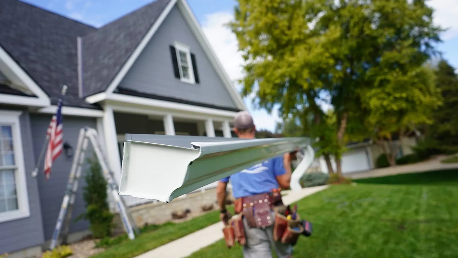 Weddle and Sons installer carrying a new seamless gutter to a home, serving Aurora, Colorado