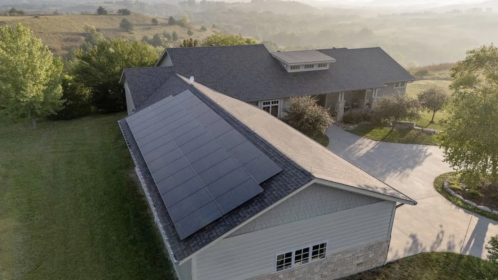 Limestone ranch home with a new shingle roof under storm clouds near Beloit, Kansas