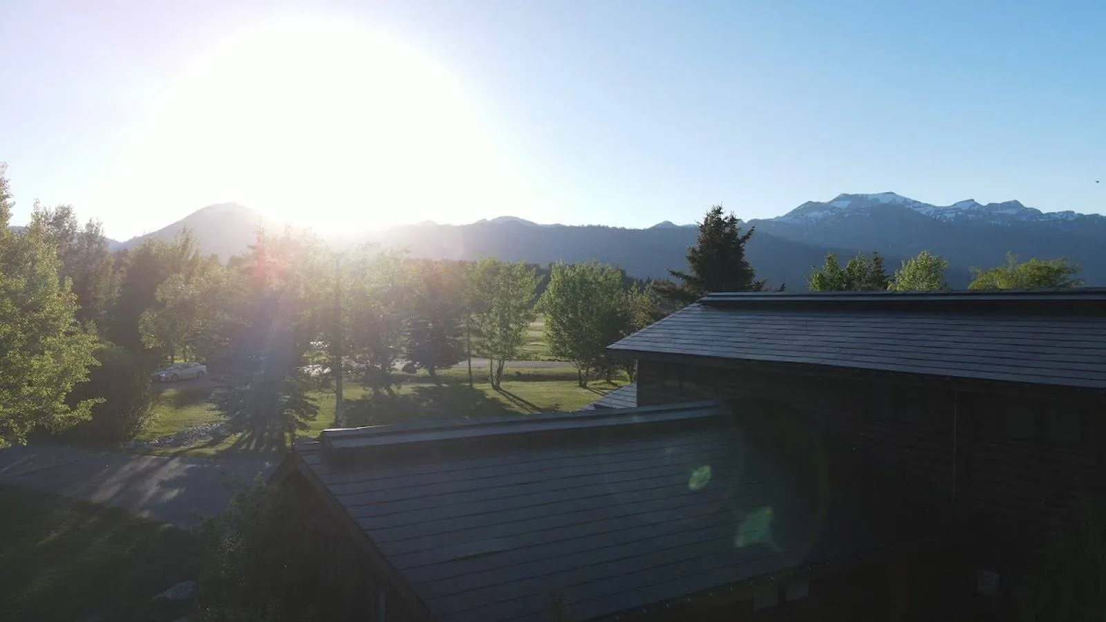 Sunrise over a Boulder, Colorado area home with a dark solar roof and mountain ridgeline in the distance