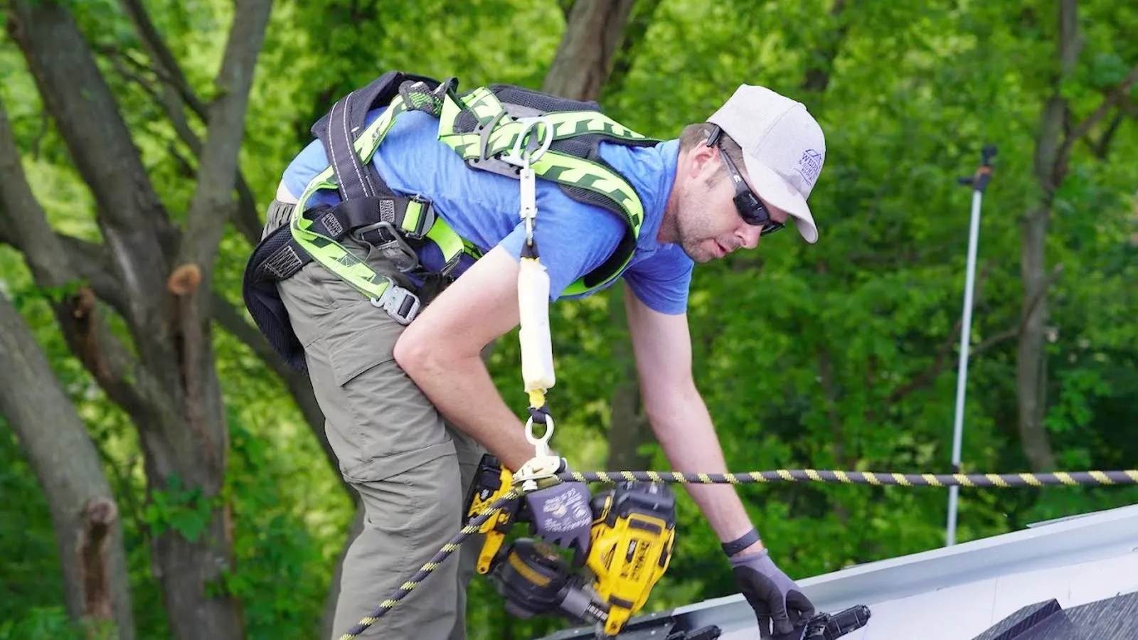Harnessed Weddle and Sons roofer fastening roof tiles on a Broomfield, Colorado area job
