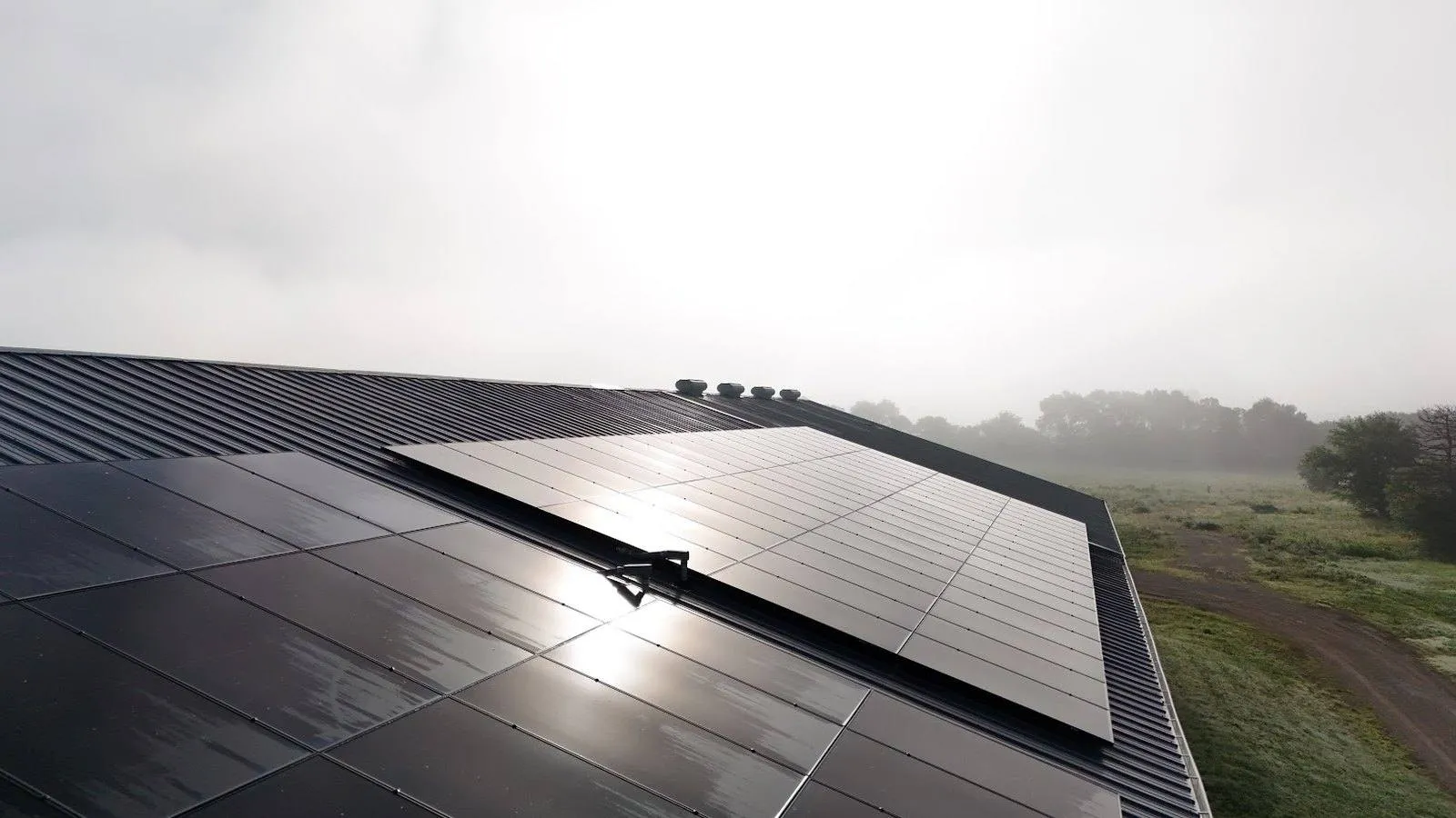 Solar panels on a standing seam metal roof near Ceresco, Nebraska on a foggy morning