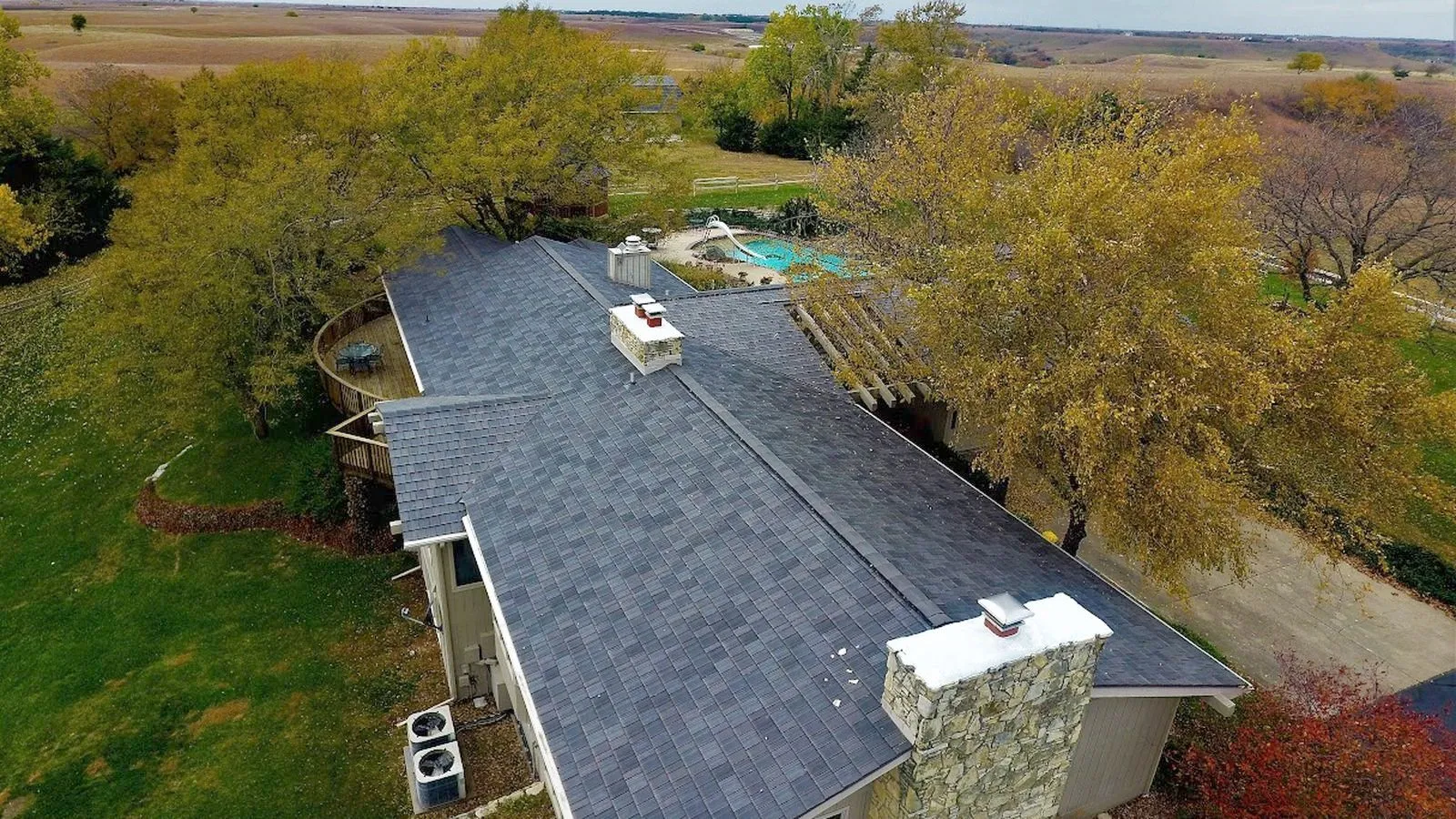 Aerial view of a ranch home with a new shingle roof overlooking open prairie near Concordia, Kansas