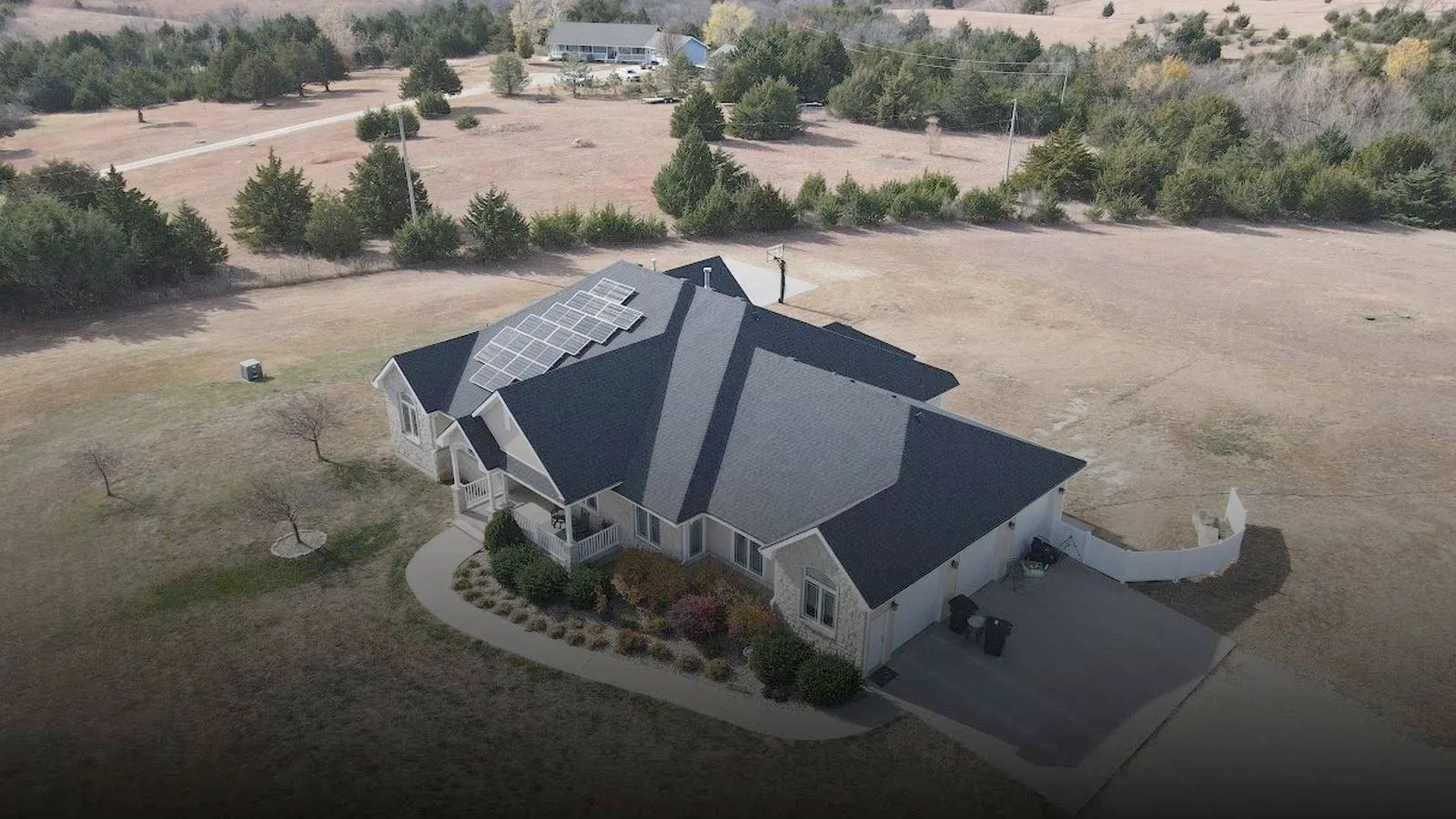 Aerial view of a Flint Hills ranch home near Council Grove, Kansas with a new shingle roof and rooftop solar panels
