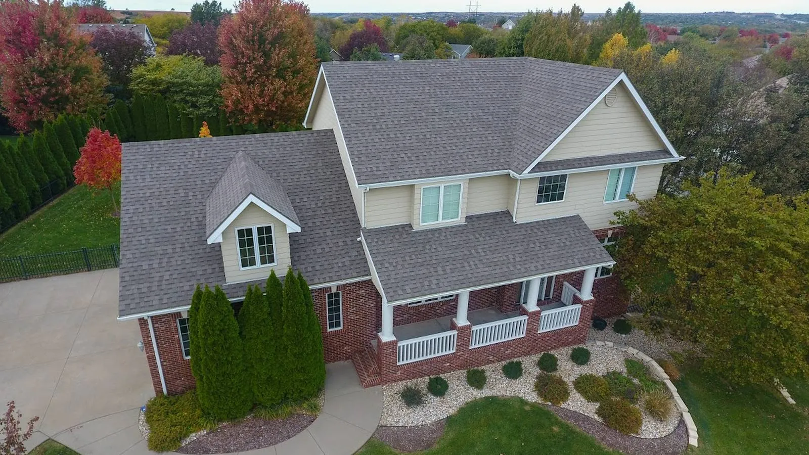 Brick two story De Soto, Kansas home with a new architectural shingle roof and front porch