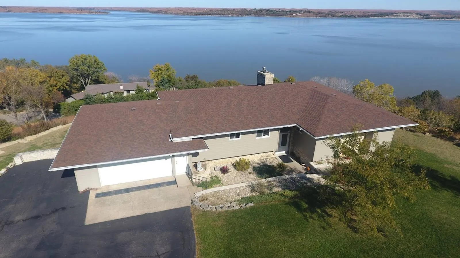 Lake view ranch home in El Dorado, Kansas with a new brown architectural shingle roof