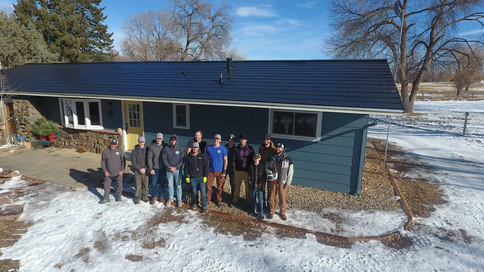 Weddle and Sons crew in front of a ranch home with a new Tesla Solar Roof near Fairbury, Nebraska in winter