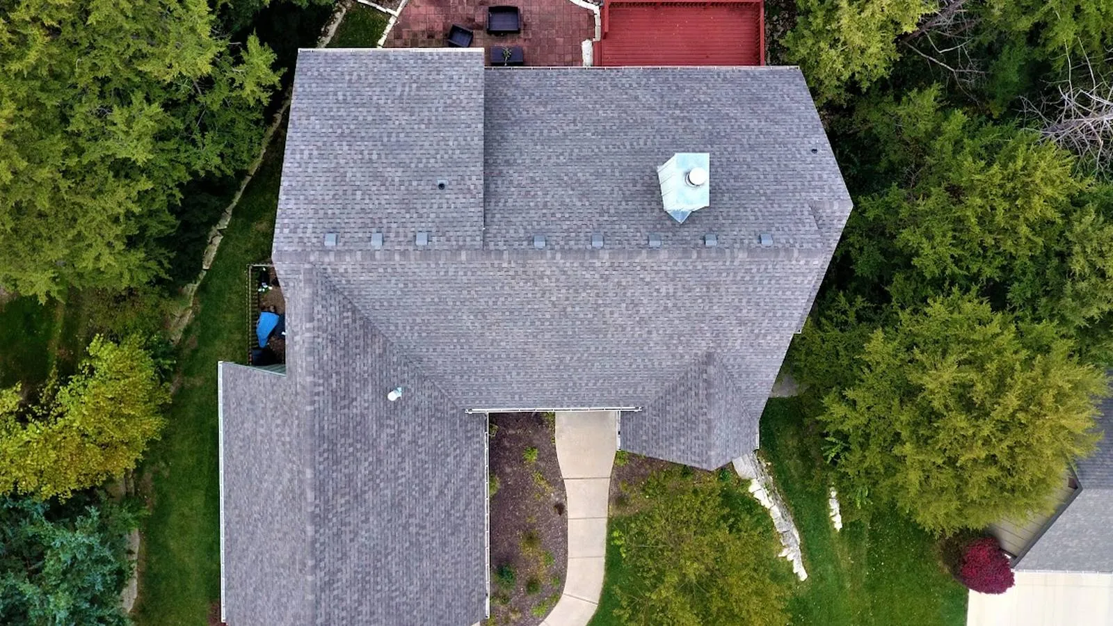 Overhead view of a Gladstone, Missouri home with a new gray architectural shingle roof among shade trees
