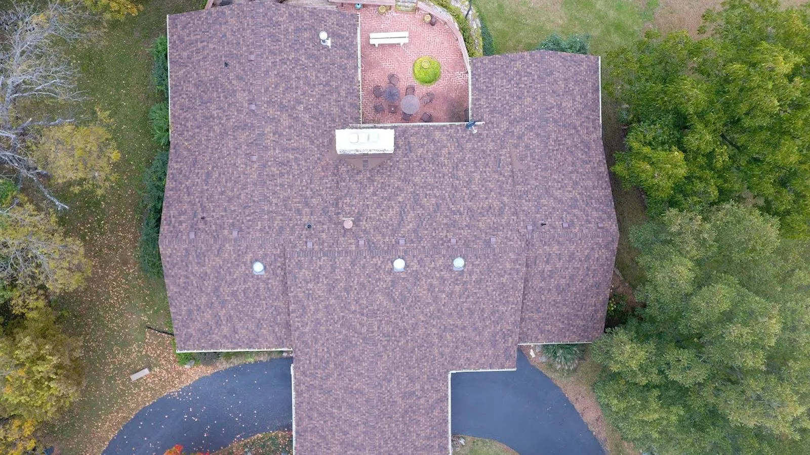 Overhead view of a Grain Valley, Missouri home with a new brown architectural shingle roof and curved driveway