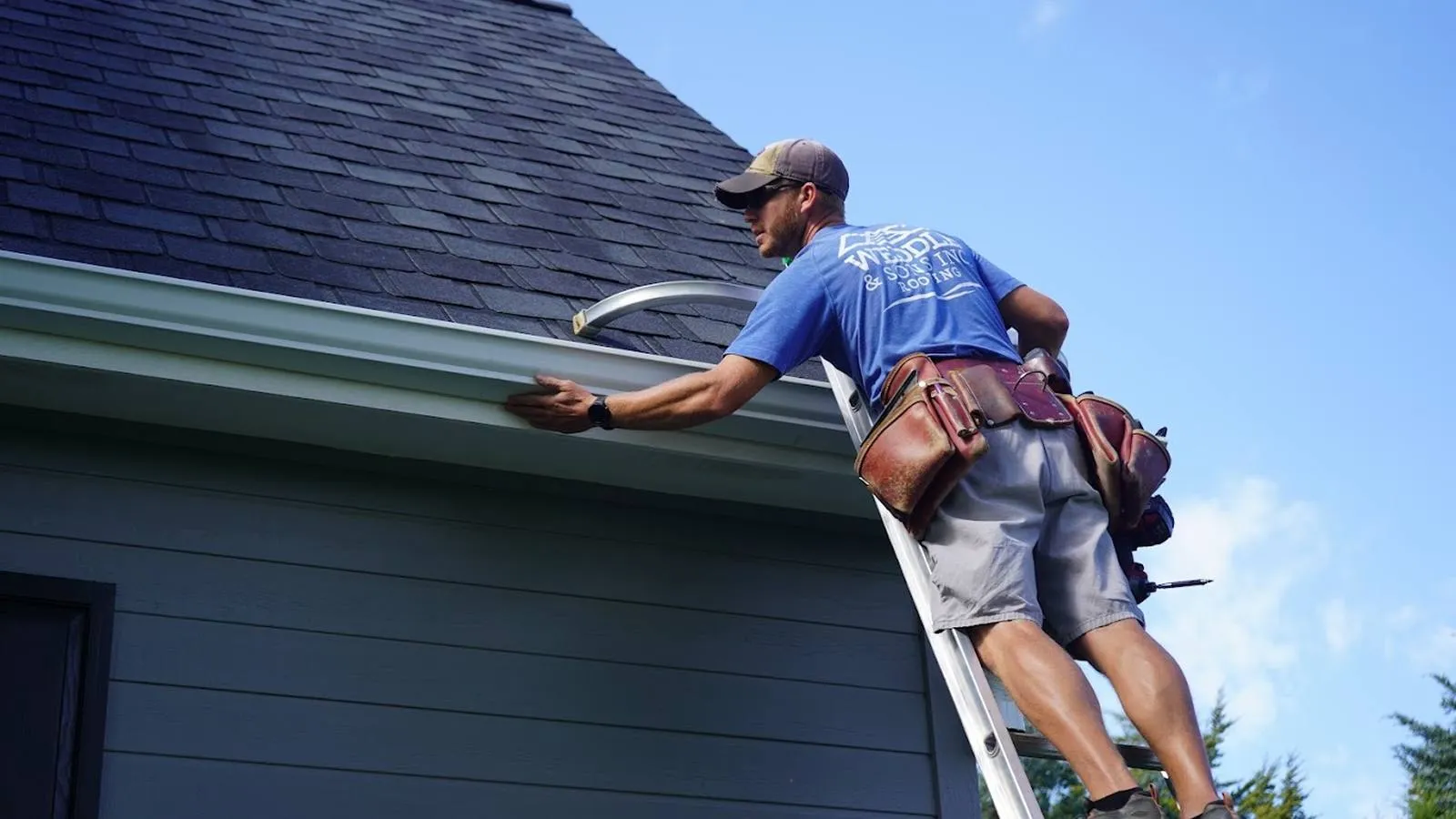 Weddle and Sons installer checking a new seamless gutter from a ladder, serving Greenwood Village, Colorado