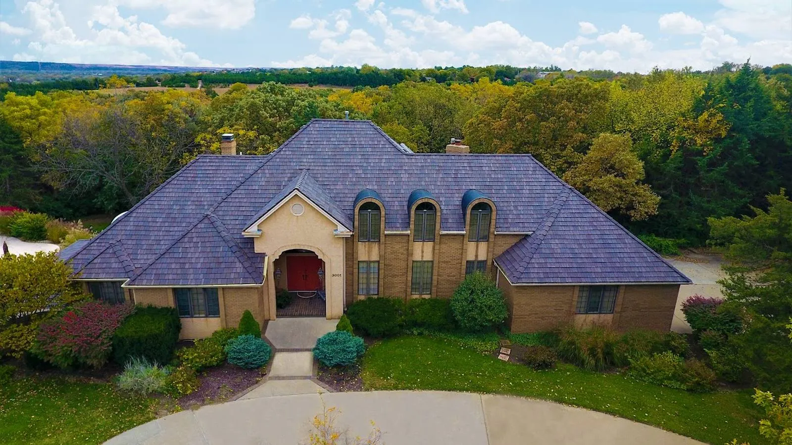 Brick home near Hiawatha, Kansas with a new purple toned synthetic slate roof and circular driveway