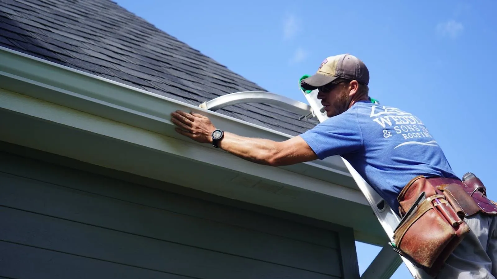 Weddle and Sons gutter installer aligning a new gutter under a blue sky, serving Highlands Ranch, Colorado