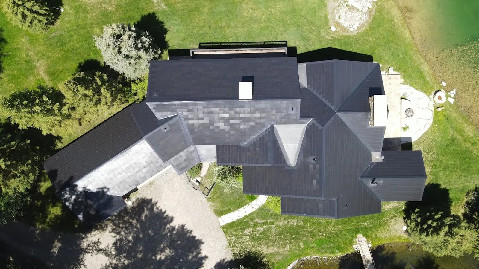 Overhead view of a completed shingle roof replacement on a large multi gable home