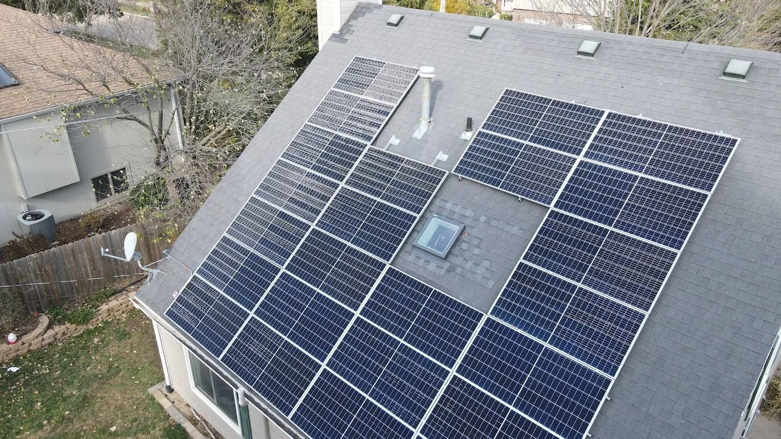 Aerial view of a Lenexa, Kansas home with a new charcoal shingle roof and a large rooftop solar array