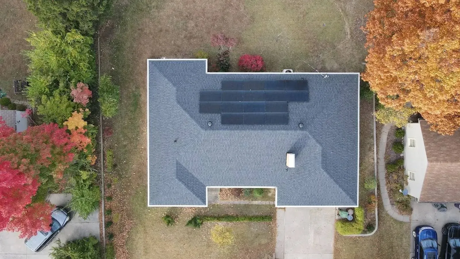 Overhead aerial view of a Louisburg, Kansas home with a new architectural shingle roof and rooftop solar panels