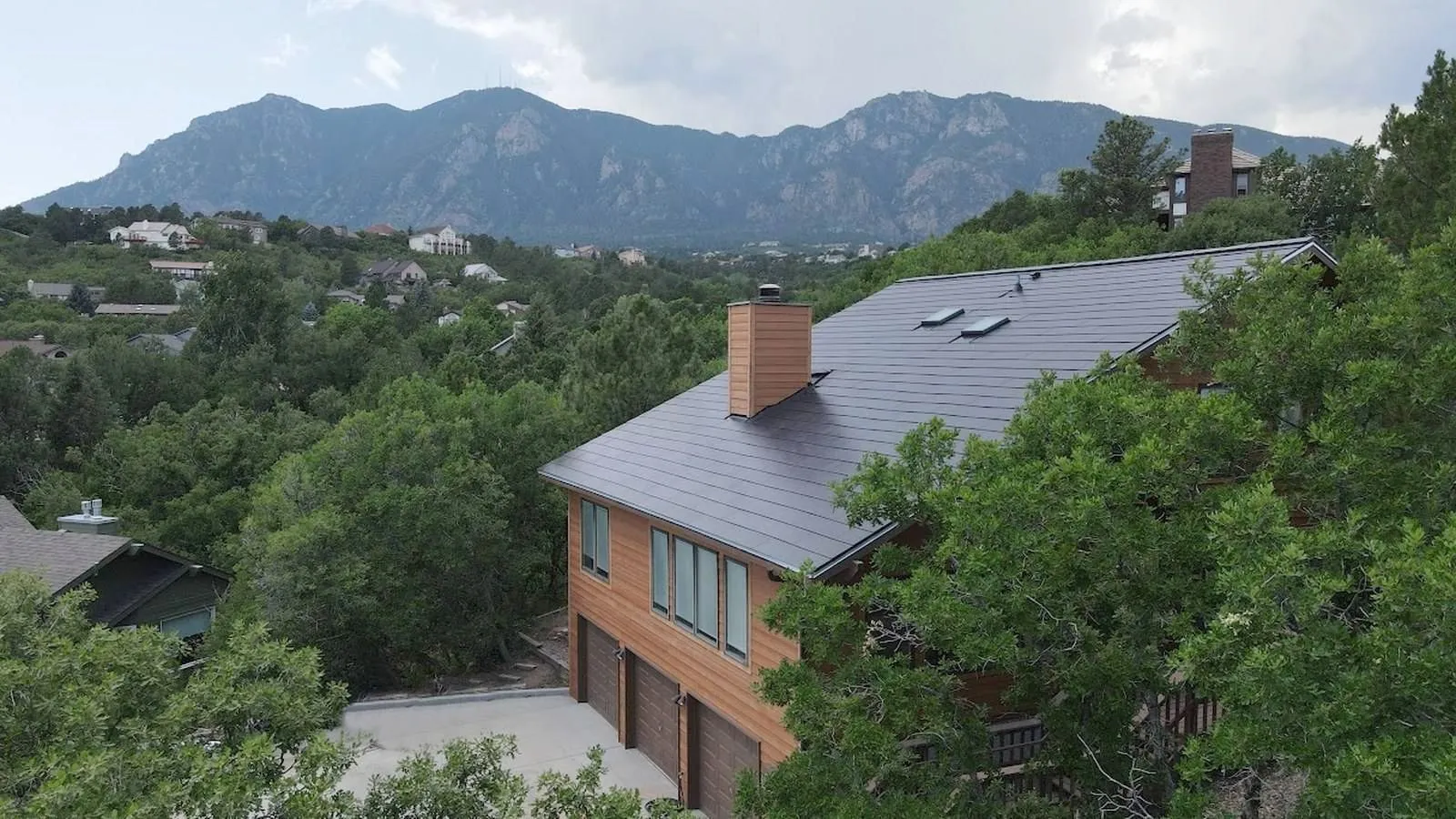 Colorado home with a dark solar roof and Front Range mountain backdrop near Loveland