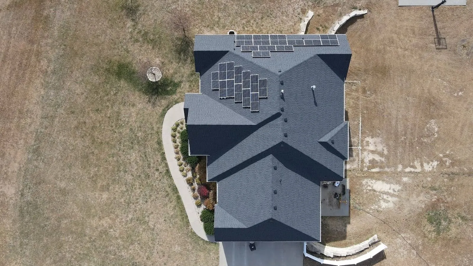 Farmstead home with a new shingle roof and rooftop solar panels near Moundridge, Kansas
