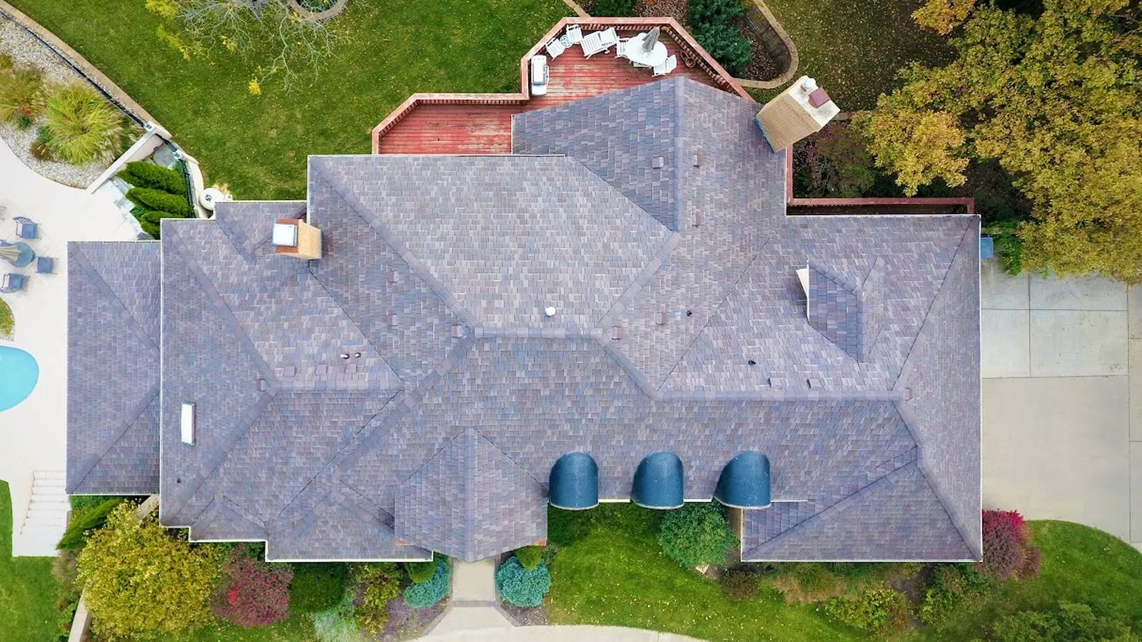 Overhead view of a large Newton, Kansas home with a new architectural shingle roof and backyard deck