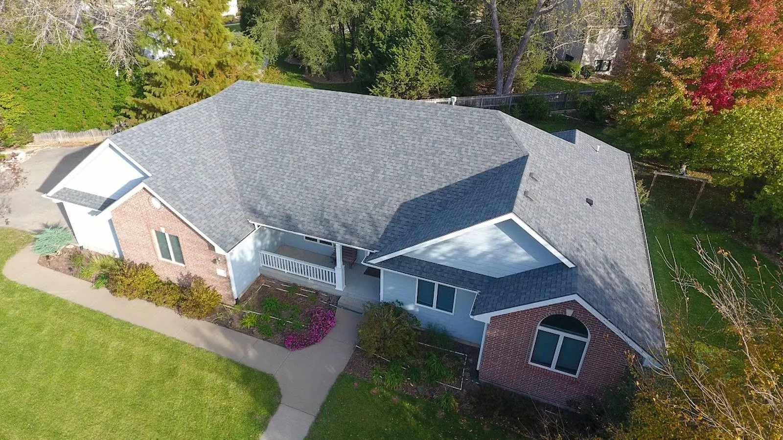 Brick ranch home in Ottawa, Kansas with a new gray architectural shingle roof and fall trees