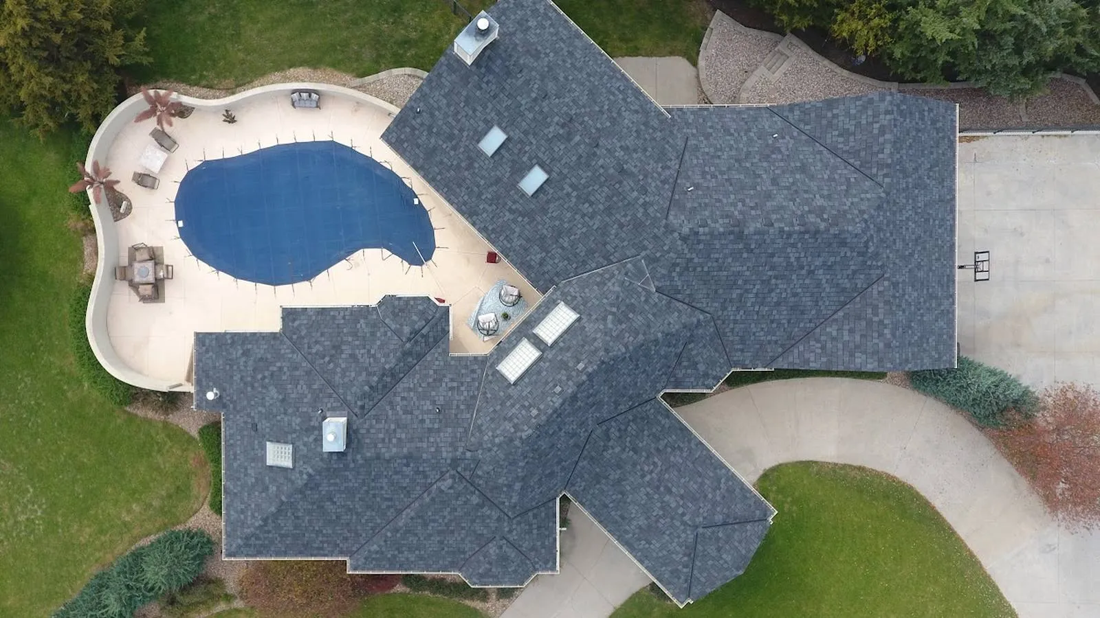 Overhead view of a Paola, Kansas home with a new charcoal architectural shingle roof and backyard pool