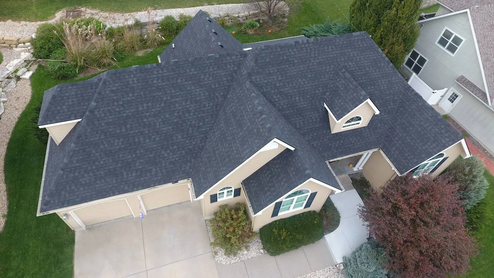 Aerial view of a Ralston, Nebraska home with a new charcoal architectural shingle roof and dormers