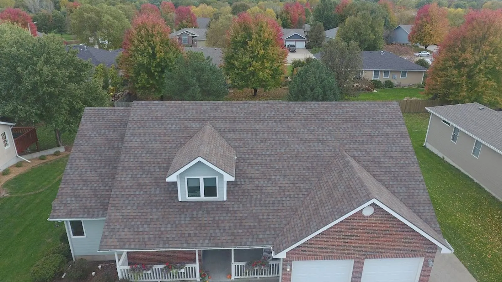 Brick Seward, Nebraska home with a new multi tone architectural shingle roof in a neighborhood of fall trees