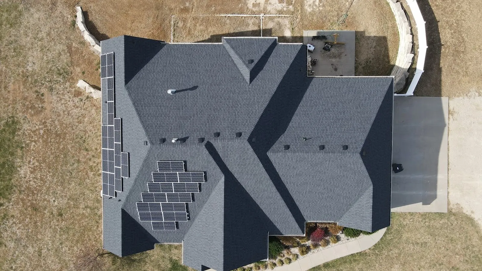 Overhead view of solar panels on a large residential shingle roof