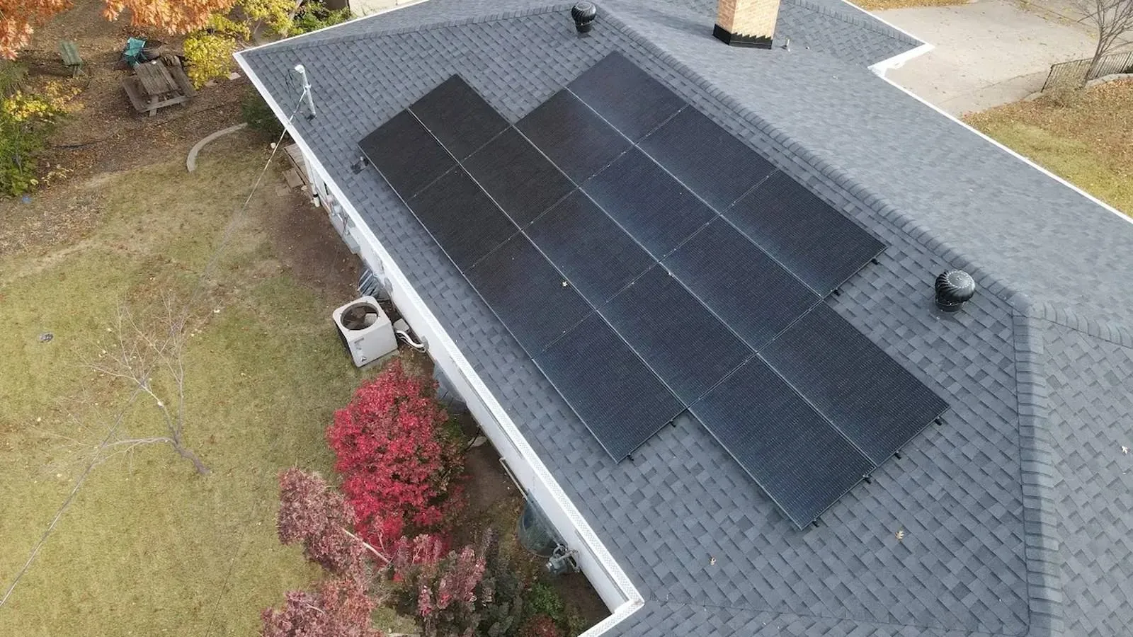 Aerial view of a Tonganoxie, Kansas home with a new dimensional shingle roof and black rooftop solar panels