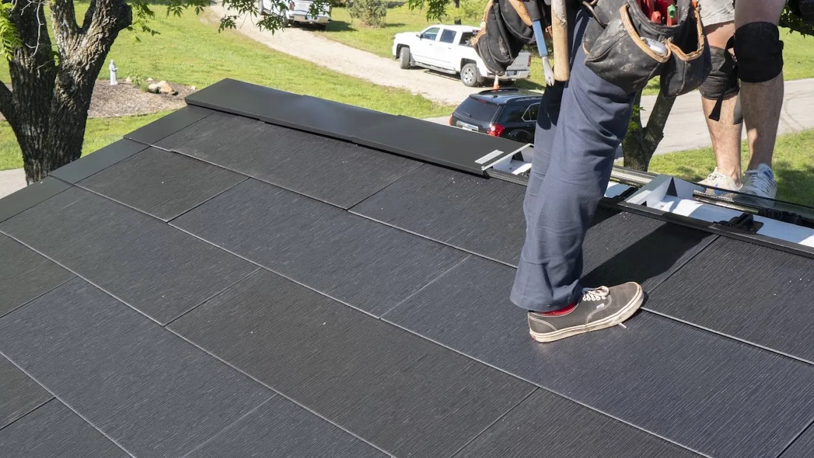 Roofer walking on newly installed solar roof tiles at an acreage home near Valley, Nebraska