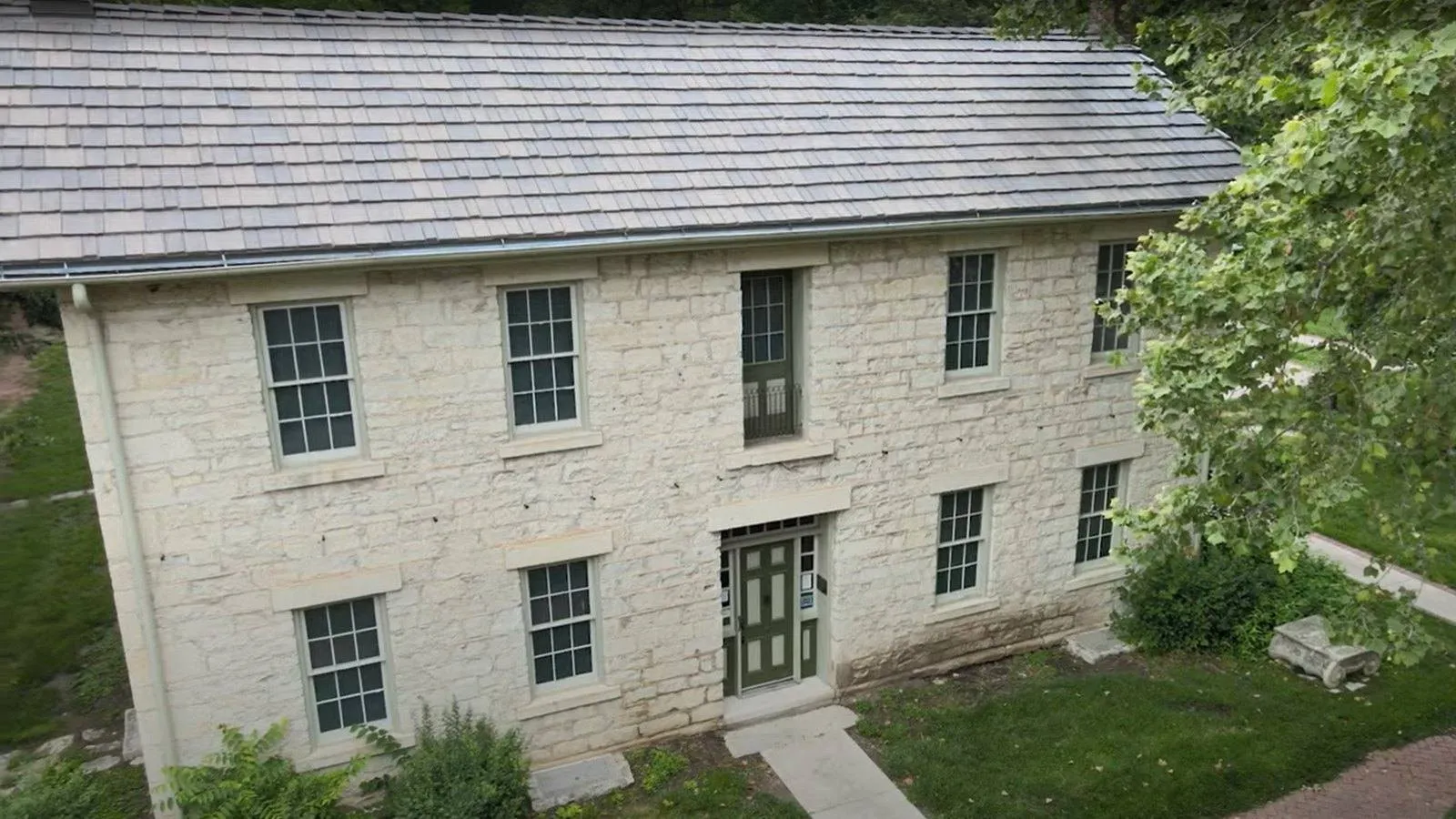 Historic native limestone building near Wamego, Kansas with a new slate look roof and copper trimmed gutters
