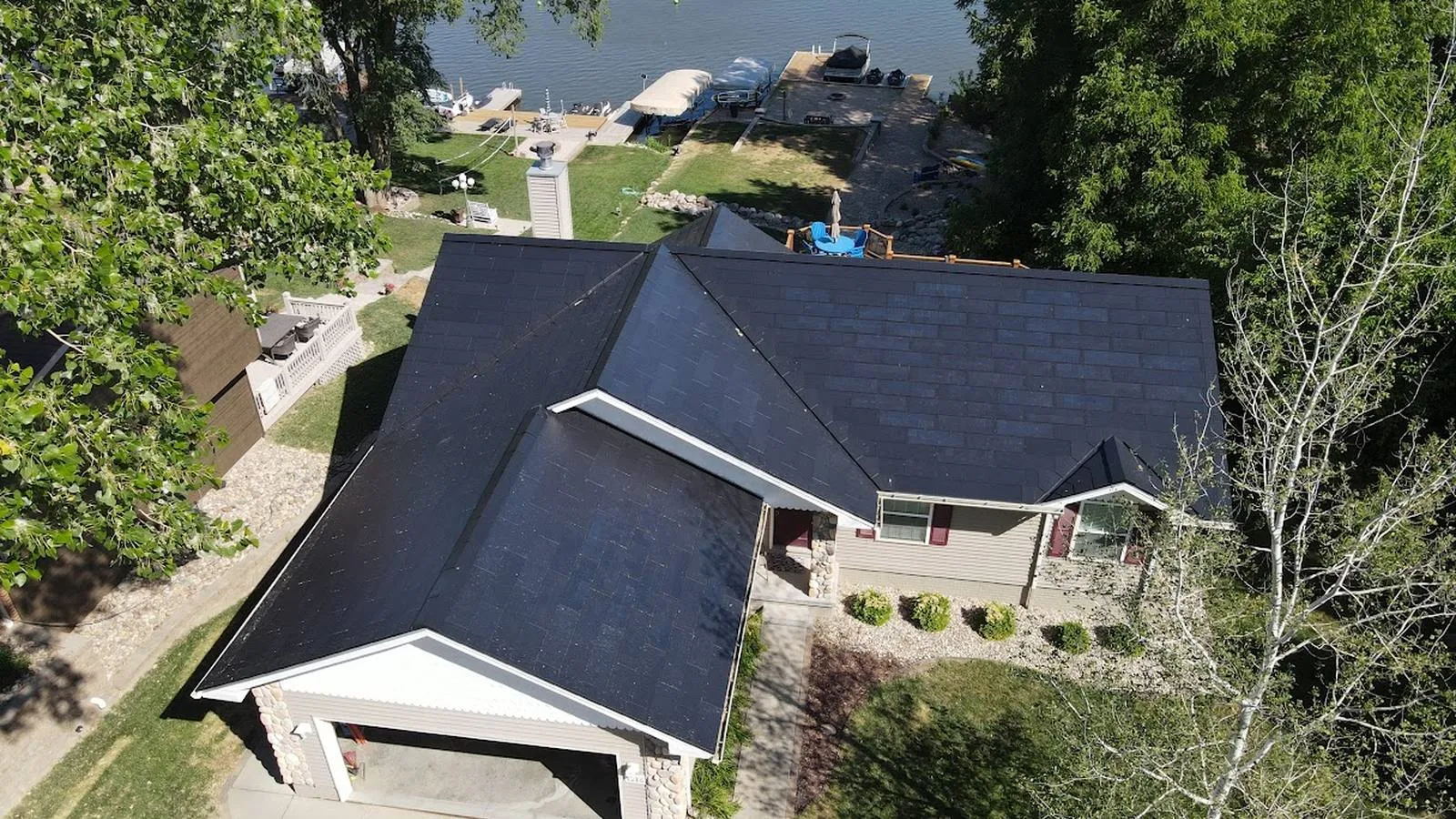 Aerial view of a Westminster, Colorado area home with a new dark solar roof beside the water
