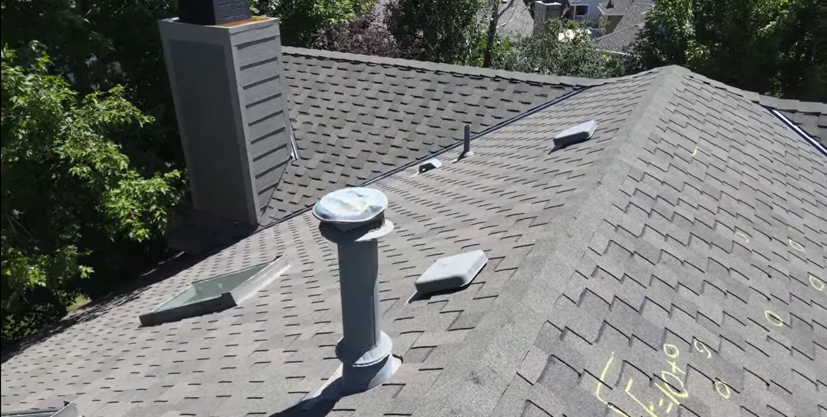 Roof inspection markings identifying damaged shingles around roof vents