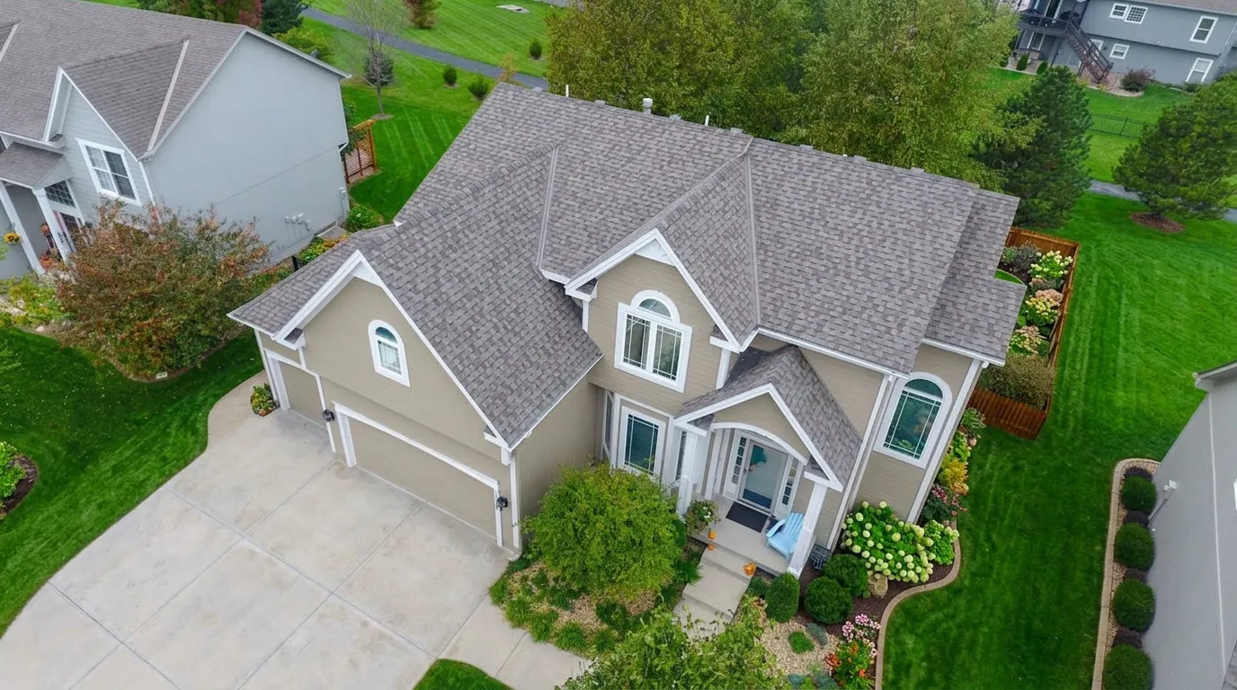 Aerial view of a beautiful two story home with a new architectural shingle roof surrounded by colorful autumn trees