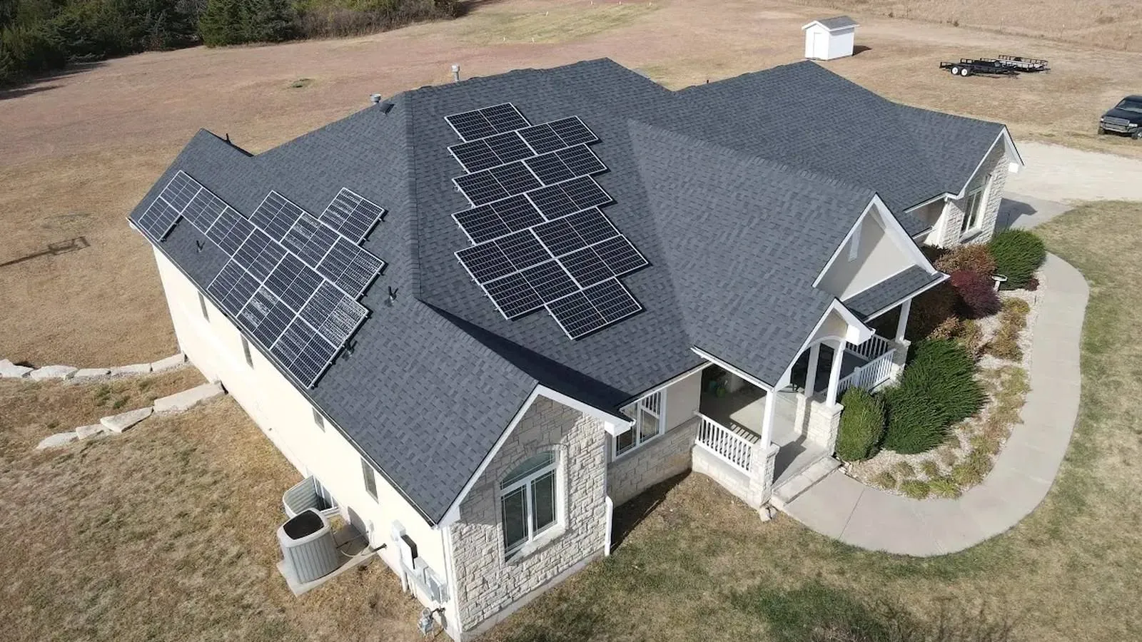 Aerial view of solar panels installed on a new shingle roof at a rural Kansas home