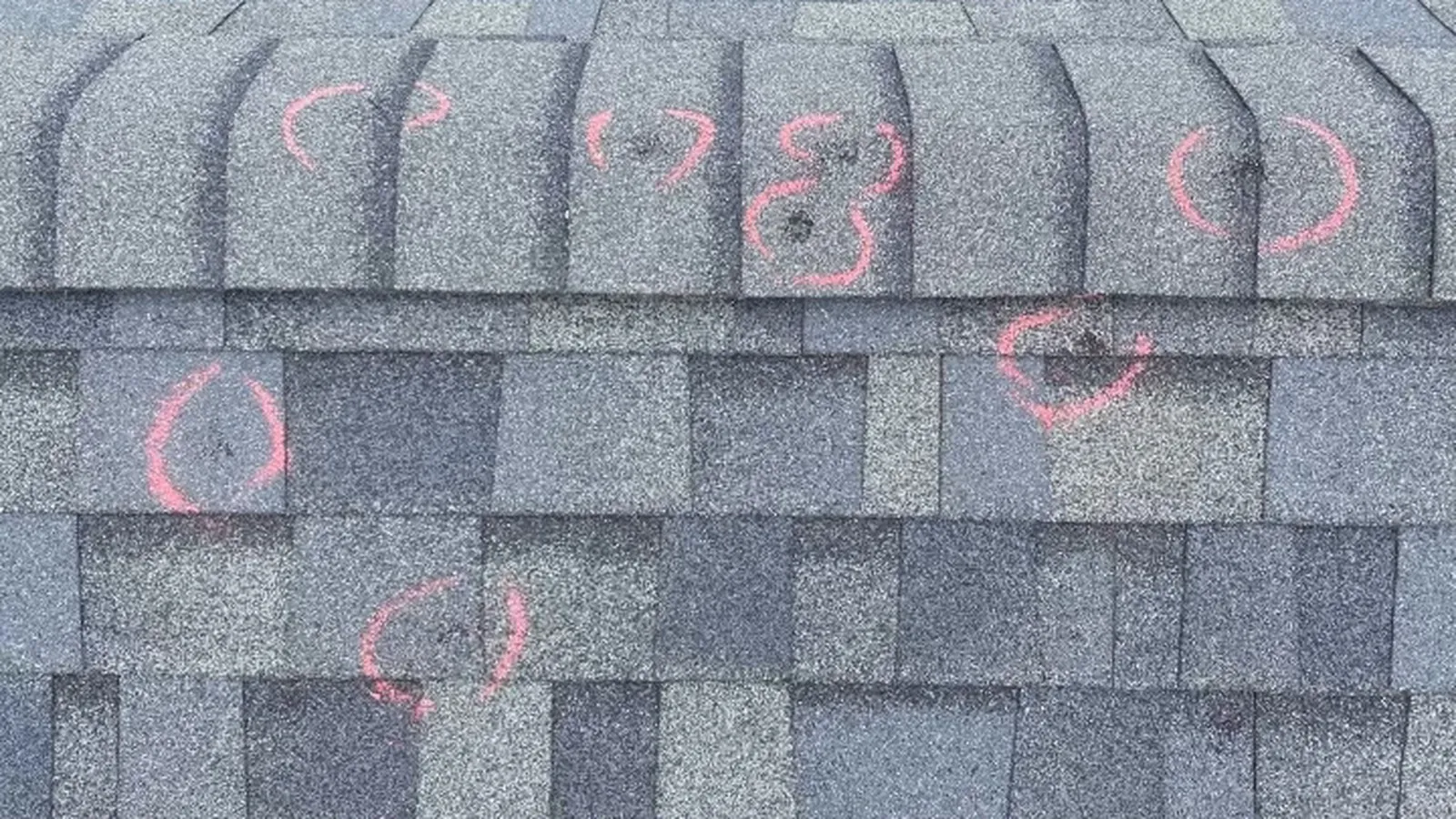Hail and wind damaged shingles on a storm hit residential roof