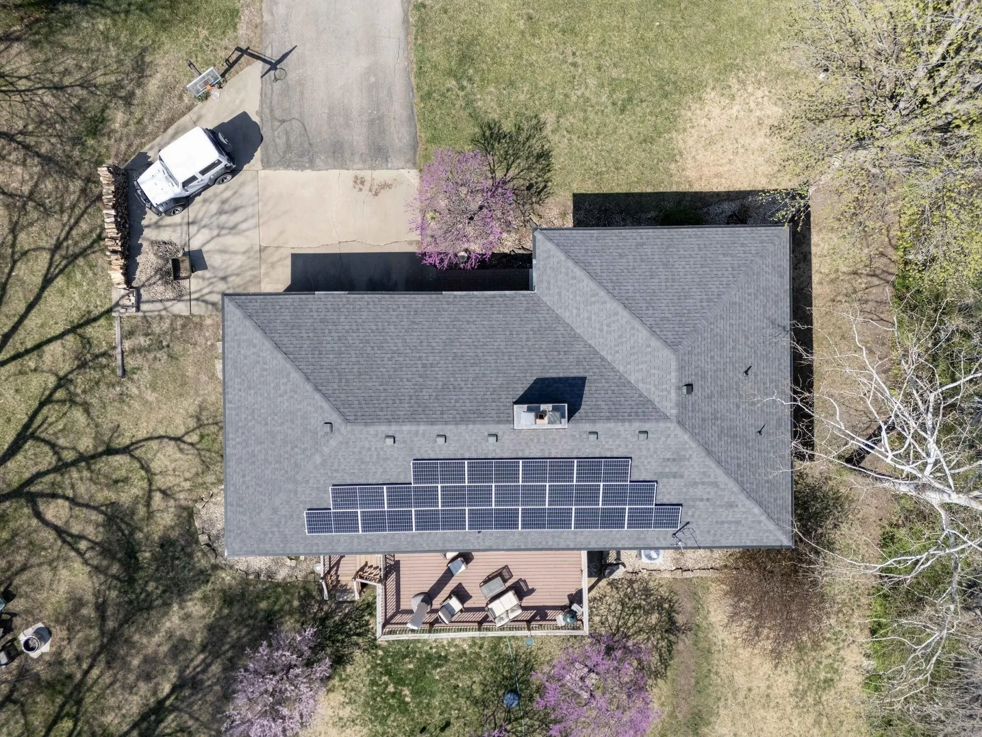 Aerial view of a home with rooftop solar panels in spring
